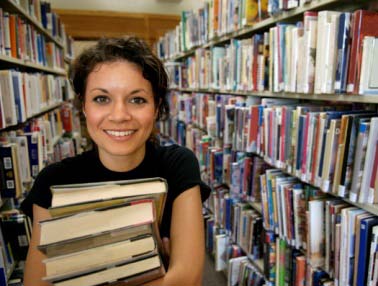 Pic of student holding books in the Library
